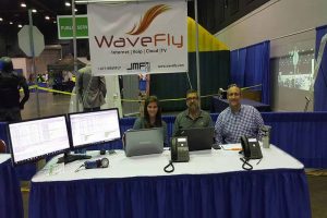 wavefly employees behind a blue booth at an expo